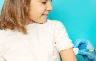 Bildet viser en ung jente som blir vaksinert i armen