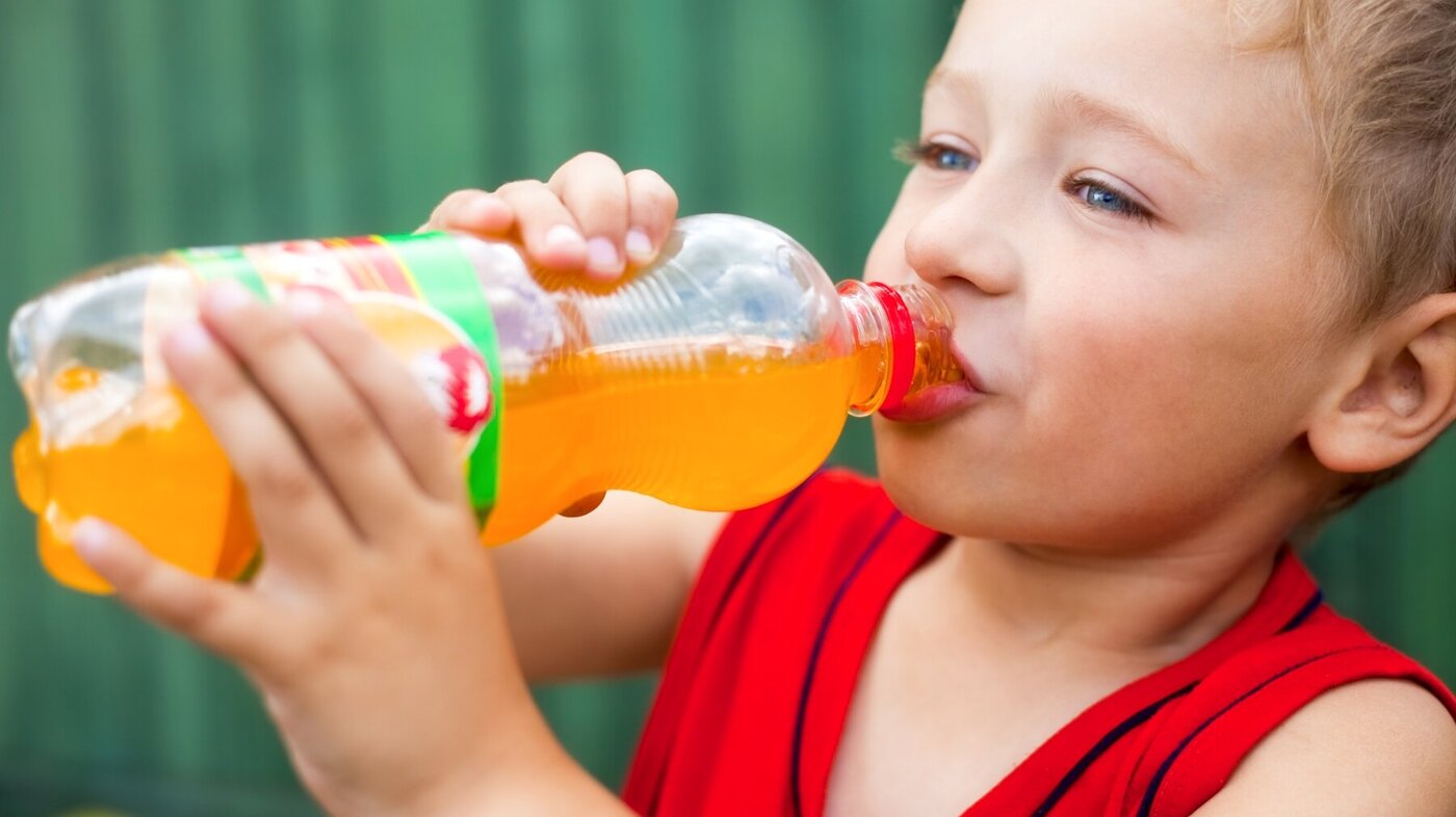 Bildet viser en liten gutt som drikker brus fra flaske