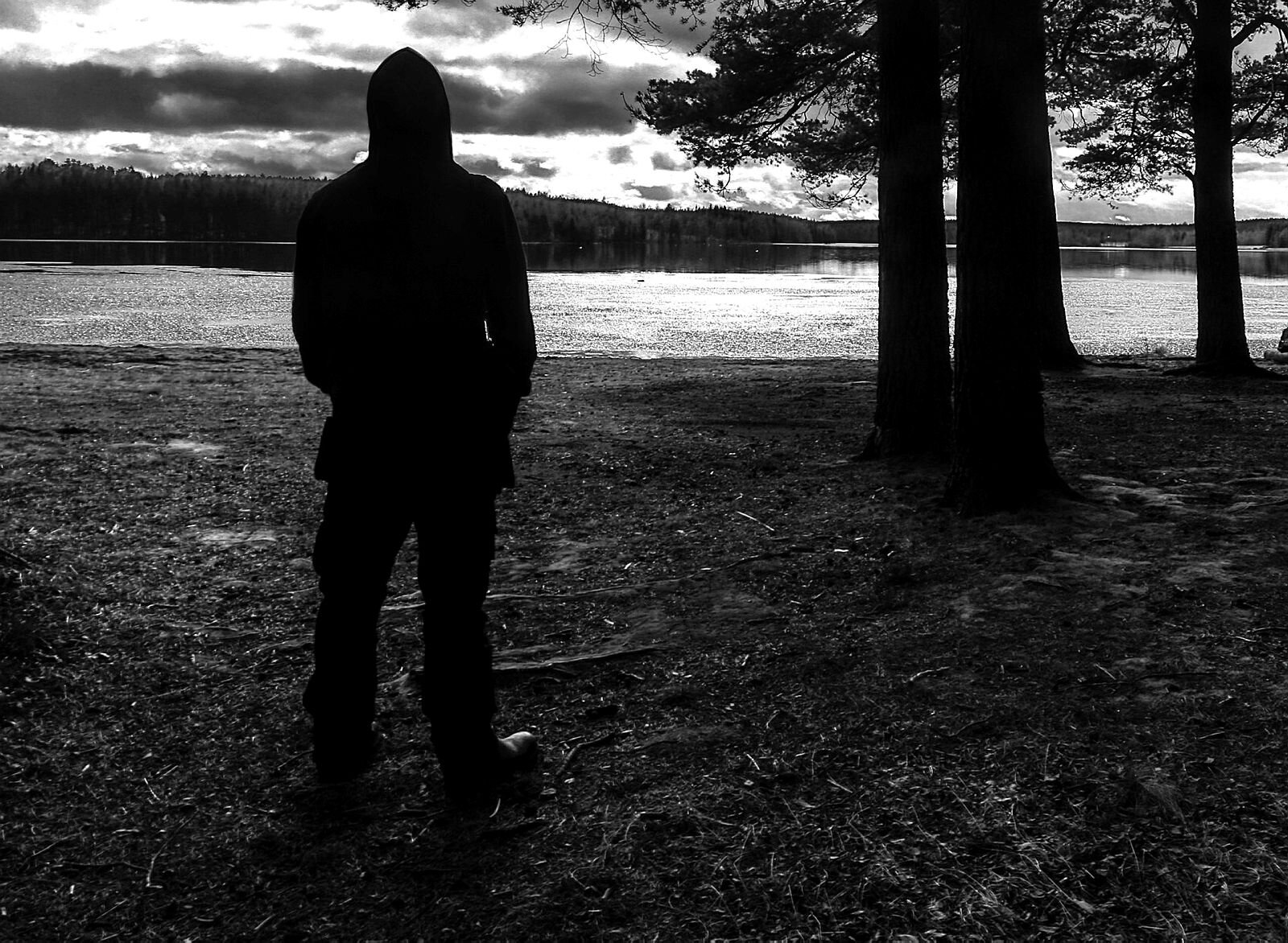 Psykisk helse Viser anonym skikkelse som står og ser ut over et vann.