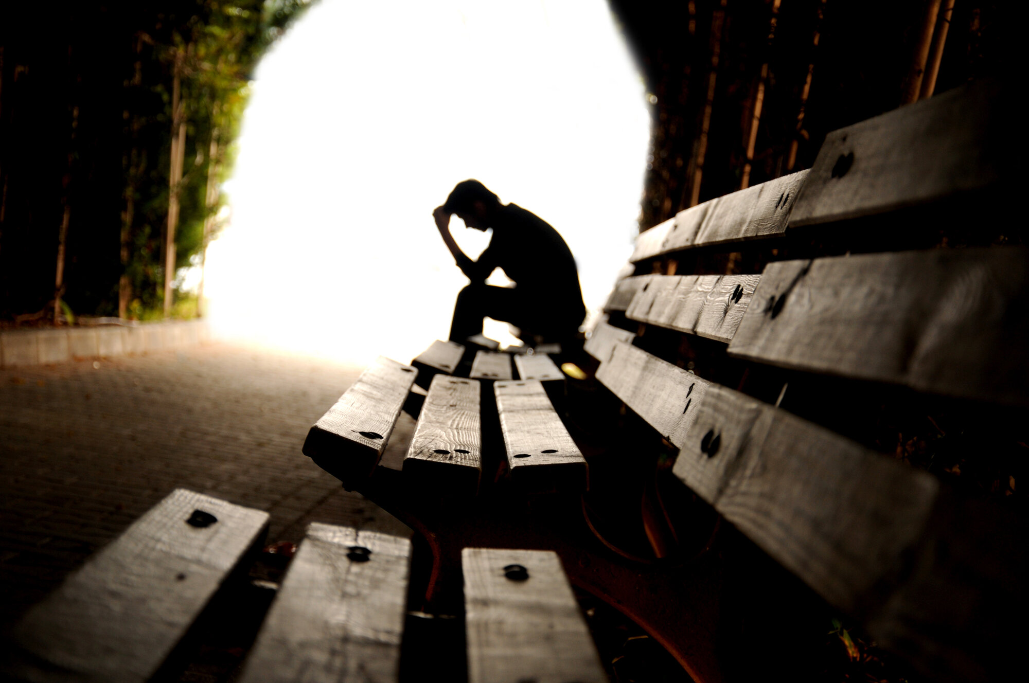 En deprimert mann på en benk. 