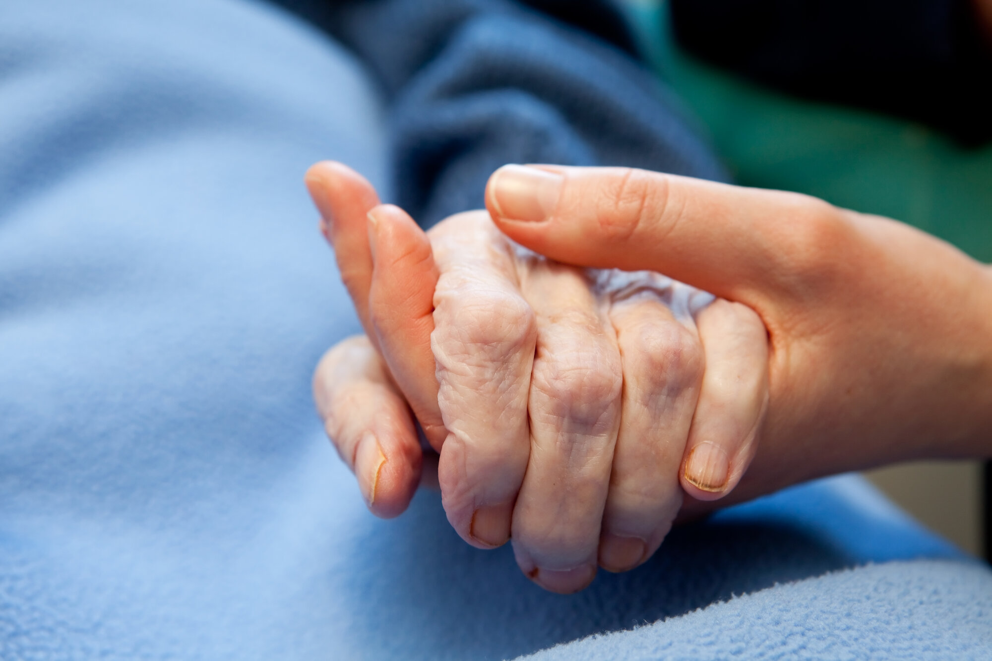 En sykepleier holder hånden til en pasient