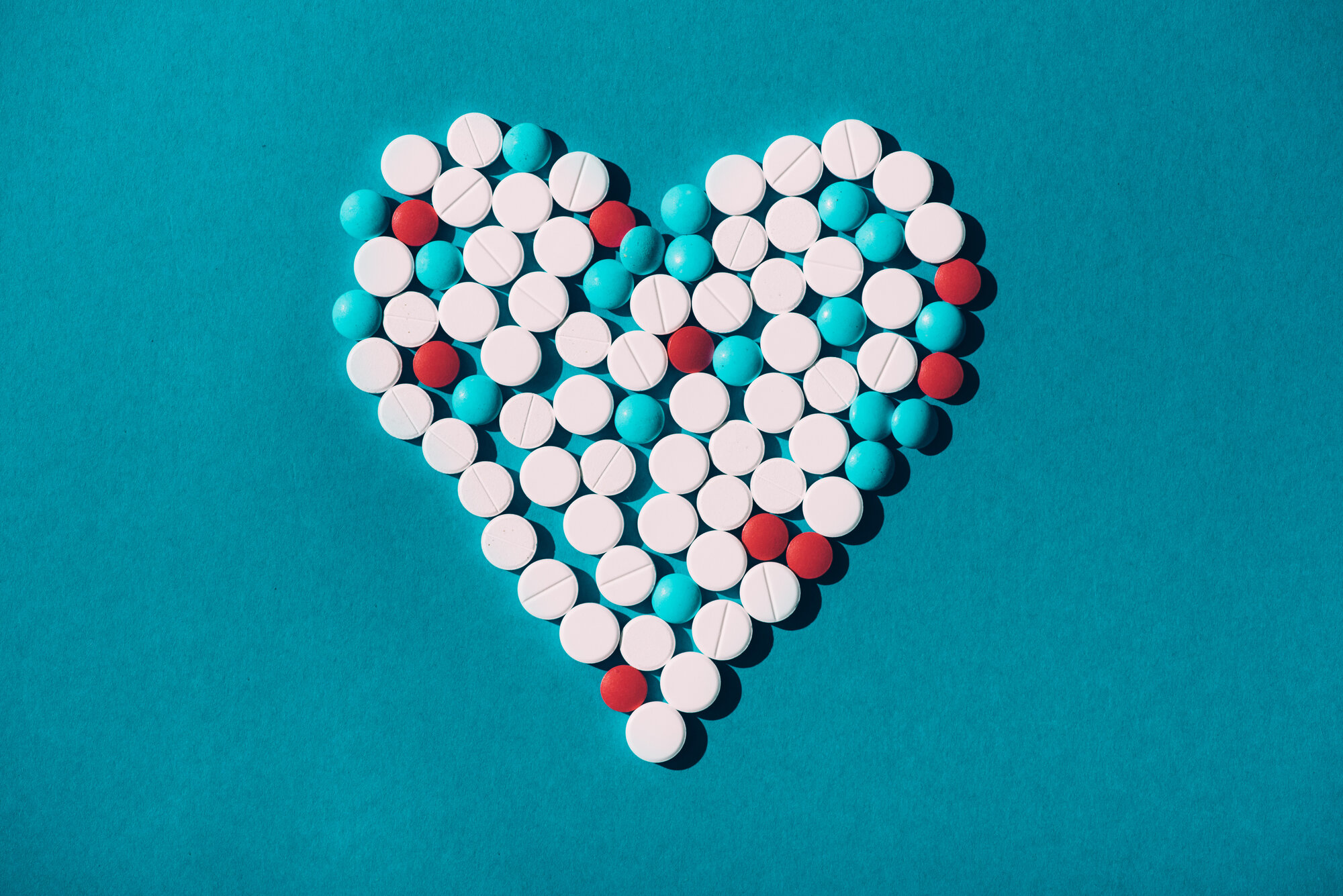 Bildet viser et hjerte laget av tabletter i hvitt, rødt og turkis