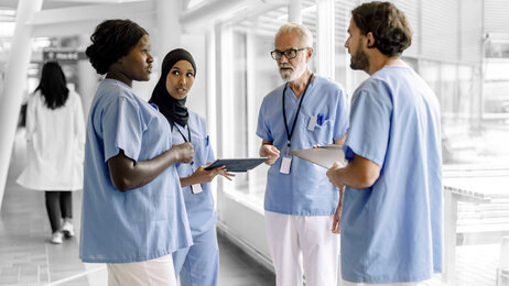 Bildet viser sykepleiere i korridorsamtale