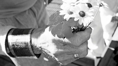 Gammel dame holder en blomsterbukett