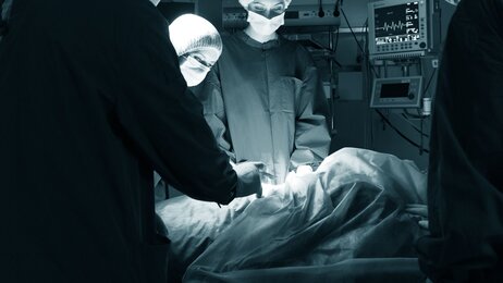 Foto fra operasjonssal hvor et team opererer en pasient
