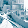 Bildet viser en syk pasient på en intensivavdeling. I forgrunnen ses et skjema og hendene til en sykepleier som skriver på skjemaet