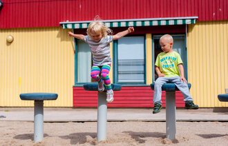 Bilde av ett som barn hopper, ett barn ser på. Illustrasjonsfoto.