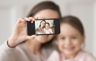 Bildet viser en mor som tar selfie av seg selv og datteren.