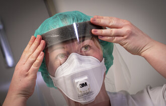 Bildet viser en sykepleier med smittevernutstyr.