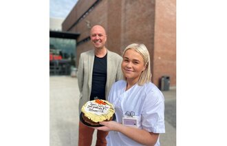 Student Lene Utzig og dekan Anders Johan W. Andersen deler ut kake til praksisplasser