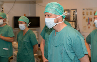 Bildet viser helseminister Bent Høie som besøker Intervensjonssenteret ved Rikshospitalet, iført munnbind