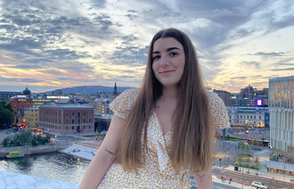 Bildet viser sykepleierstudent Emily Kolstad Stephensen på toppen av Operahuset i Oslo en sommerdag