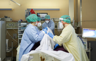 Bildet viser sykepleiere som snur en intensivpasient til mageleie