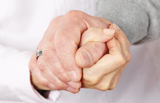 Bildet viser to hender som holder hverandre.