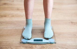 Bildet viser bena på en jente som står på en vekt