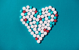 Bildet viser et hjerte laget av tabletter i hvitt, rødt og turkis