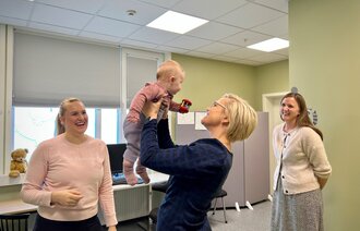 Helseministeren løfter baby på Saupstad helsestasjon i Trondheim