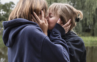 Bildet viser to ungdommer som kysser.