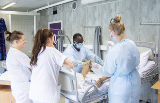 Helsesykepleierne Jean Karekezi og Kristin Olsen Holst øver på å sette inn kateter på en simuleringsdokke. De blir veiledet av slagsykepleier Adrianne Johnsen og fagutviklingssykepleier Marthe Bjørnvik.