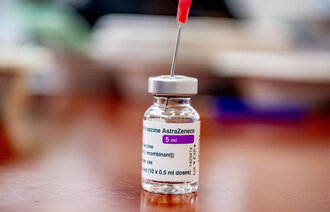 Bildet viser en flaske med AstraZenica vaksine med en kanyle