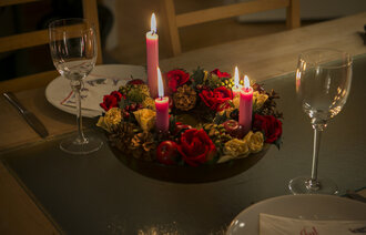 Bildet viser et middagsbord som er pyntet med julelys og blomster