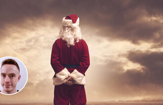 Bildet viser en julenisse med armene på ryggen som ser utover horisonten