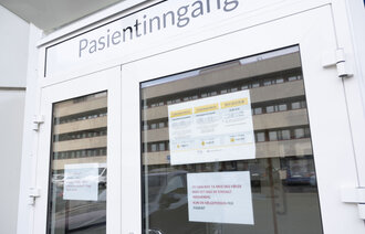 Bildet viser Sørlandets sykehus og legevakt i Kristiansand med plakater og varsler om Coronavirus.