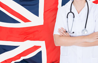 Bildet viser et britisk flagg i bakgrunnen og overkroppen til en person i hvit uniform