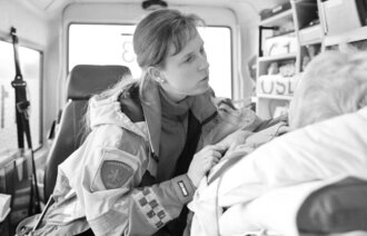 Sykepleier overvåker pasient i ambulanse
