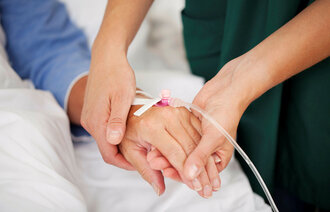 Sykepleier holder pasienthånd