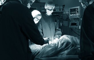 Foto fra operasjonssal hvor et team opererer en pasient