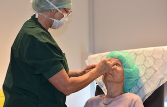 Bildet viser en sykepleier som gir injeksjon i øyet til en pasient