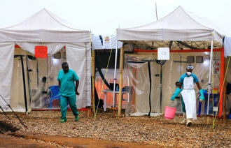 Bildet viser helsearbeidere som gjør klart et behandlingssenter for ebola.