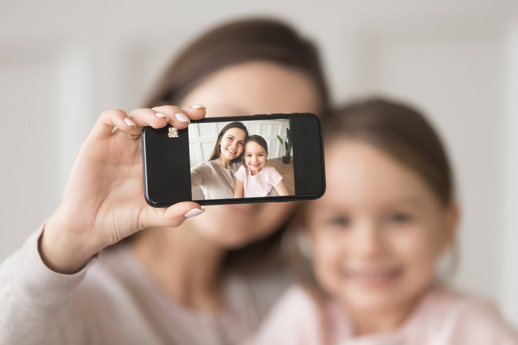 Bildet viser en mor som tar selfie av seg selv og datteren.