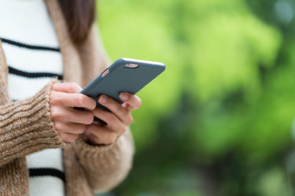 Bildet viser en kvinnehånd som holder en smarttelefon.