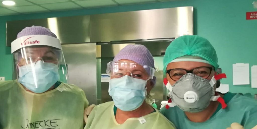 Bildet viser tre sykepleiere med smittevernutstyr.