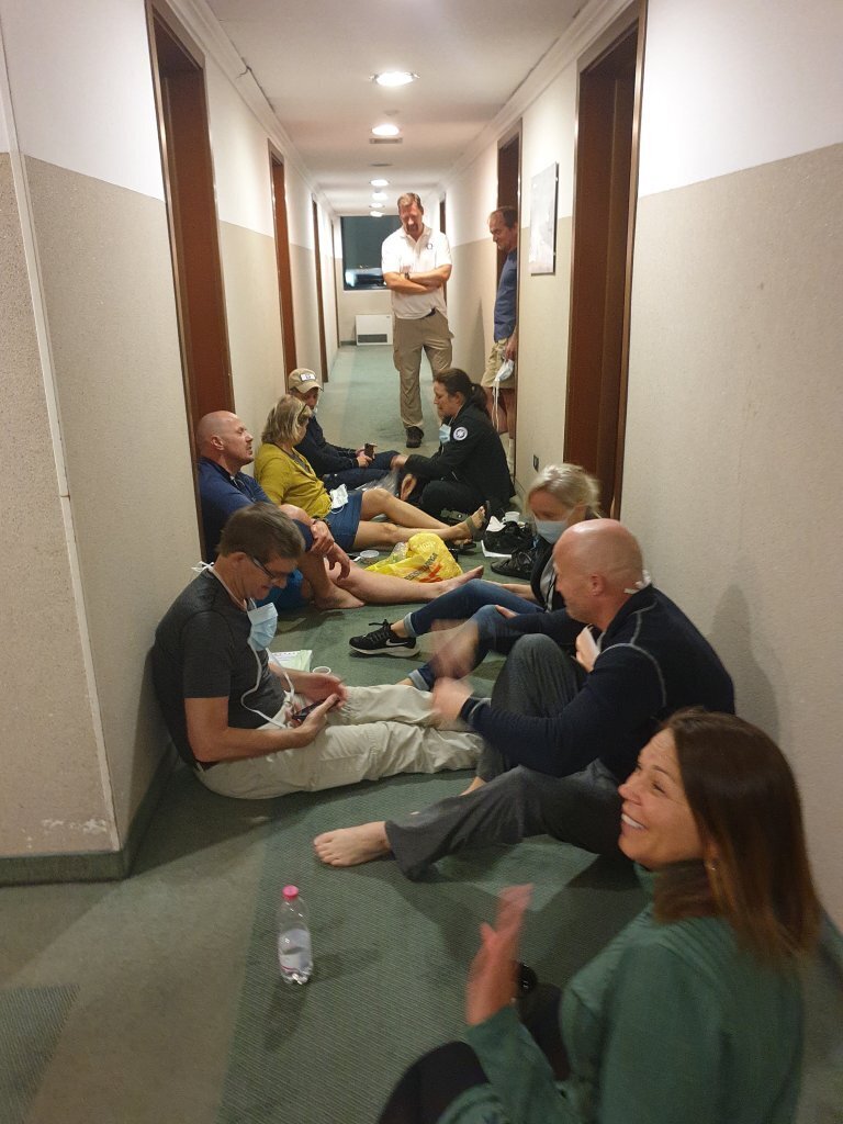 Bildet viser en medisinsk innsatsteam som sitter i en korridor og prater.