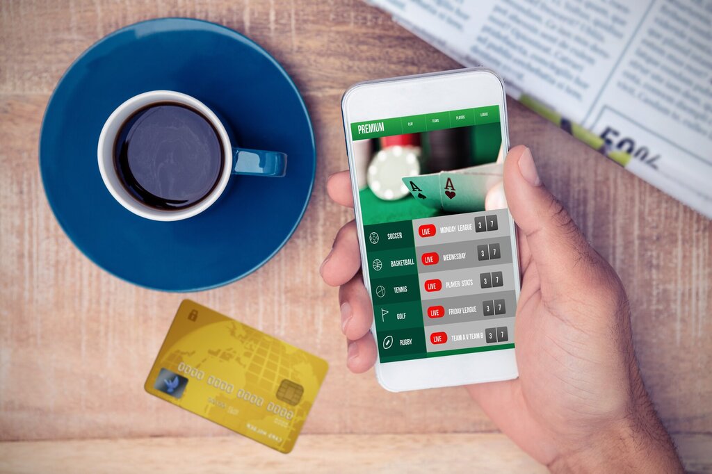 Bildet viser en hånd som holder en mobil med online pengespill