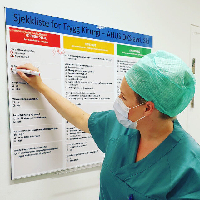 Bildet viser operasjonssykepleier som krysser av på sjekkliste.