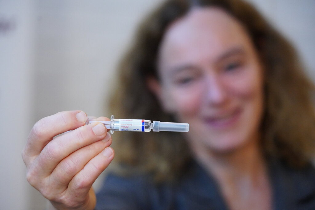 Bildet viser Camilla Stoltenberg som holder frem en influensavaksine
