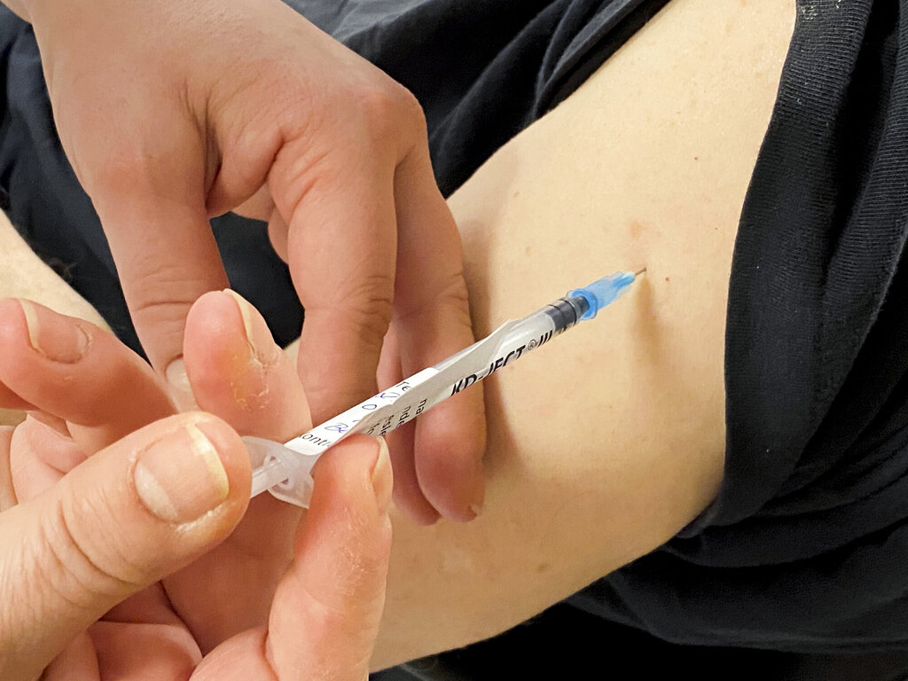 Bildet viser en arm det blir satt vaksine i.