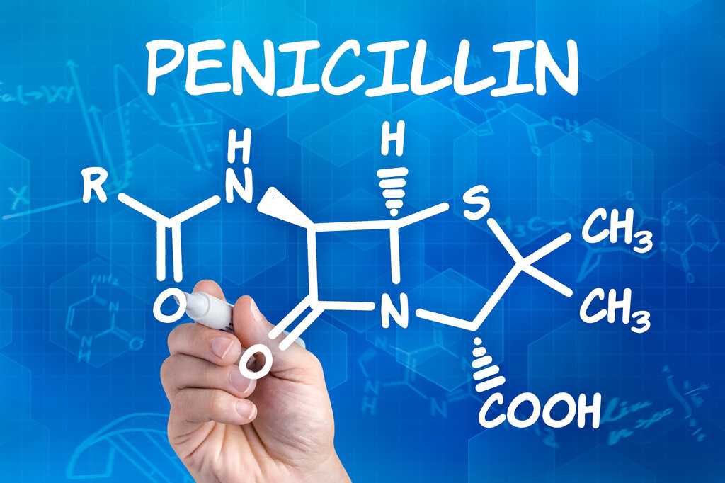 Bildet viser en hånd som skriver formelen for penicillin på en tavle.