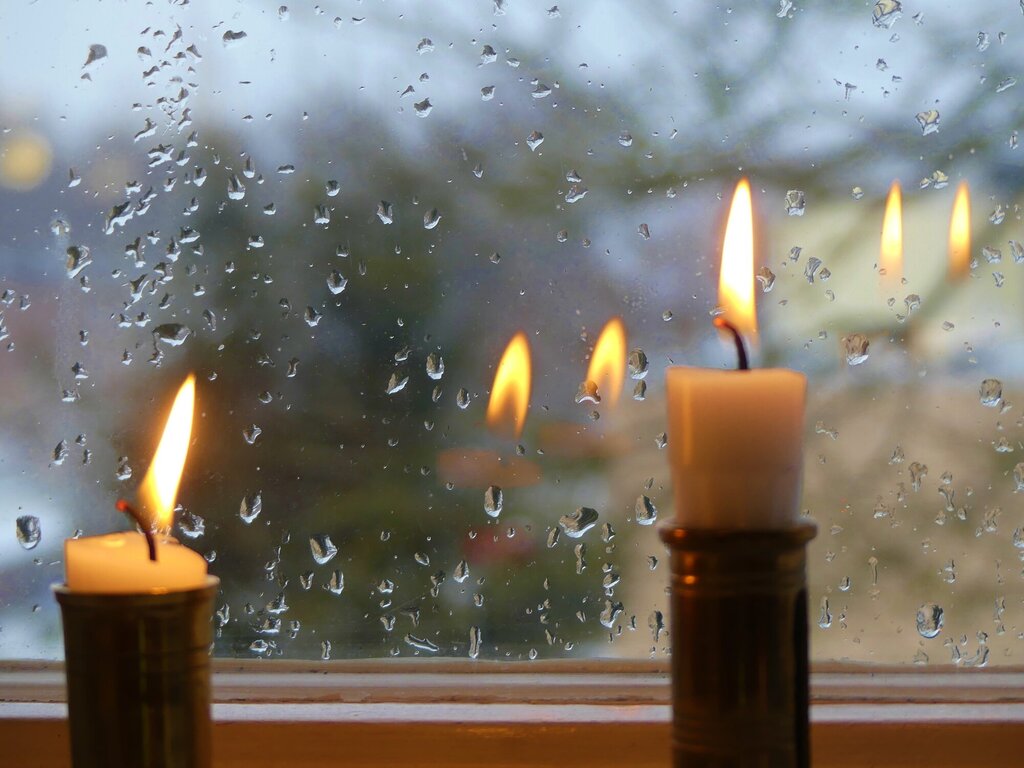 Bildet viser to stearinlys i et vindu