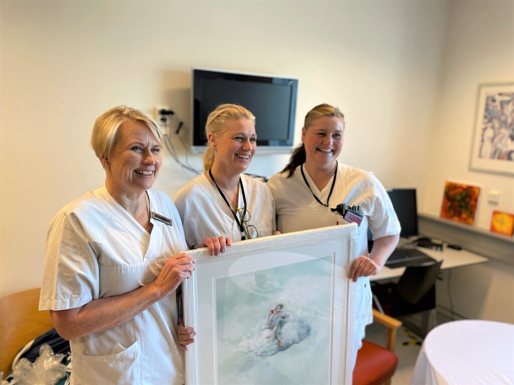 Bildet viser Sylvi Vullum og to kolleger som holder frem et bilde.