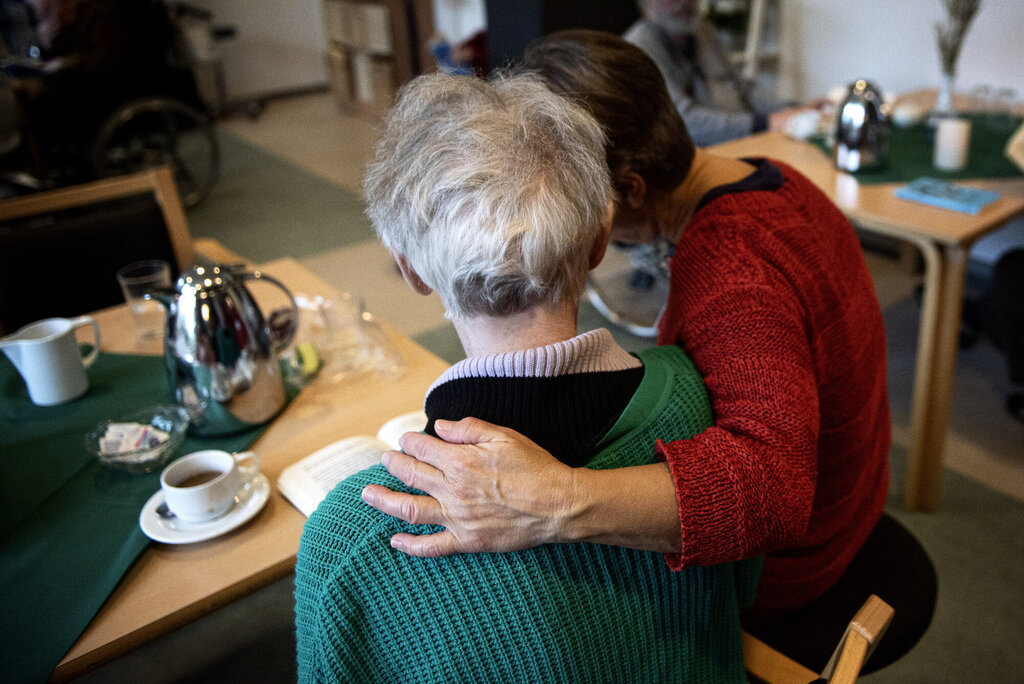 Bildet viser en pleier som holder rundt en pasient på demenspleiehjemmet Dagmarsminde i Danmark