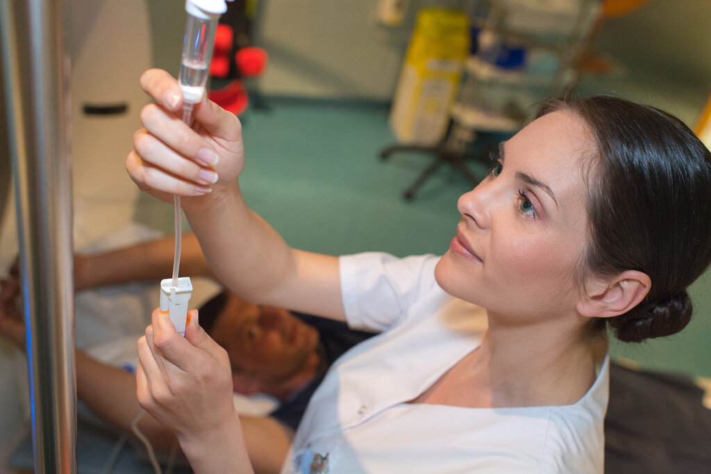 Bildet viser en sykepleier som gir intravenøs medisin