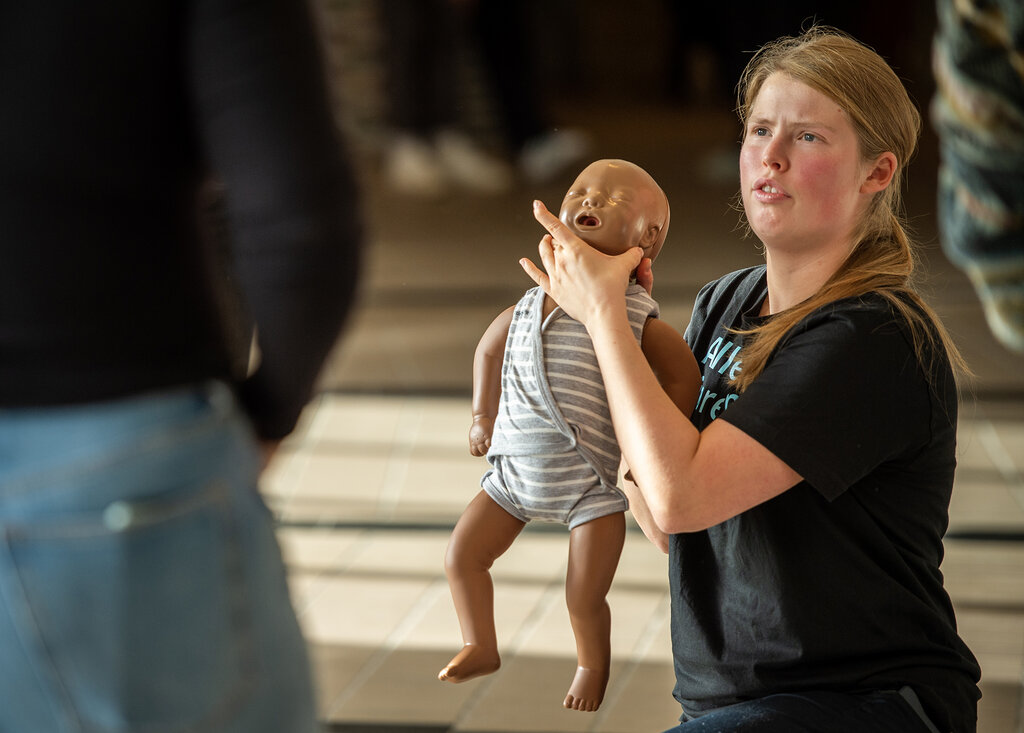 Bildet viser paramedisinstudent Marie Skavdal-Stene med en babydukke under en førstehjelpsøvelse.