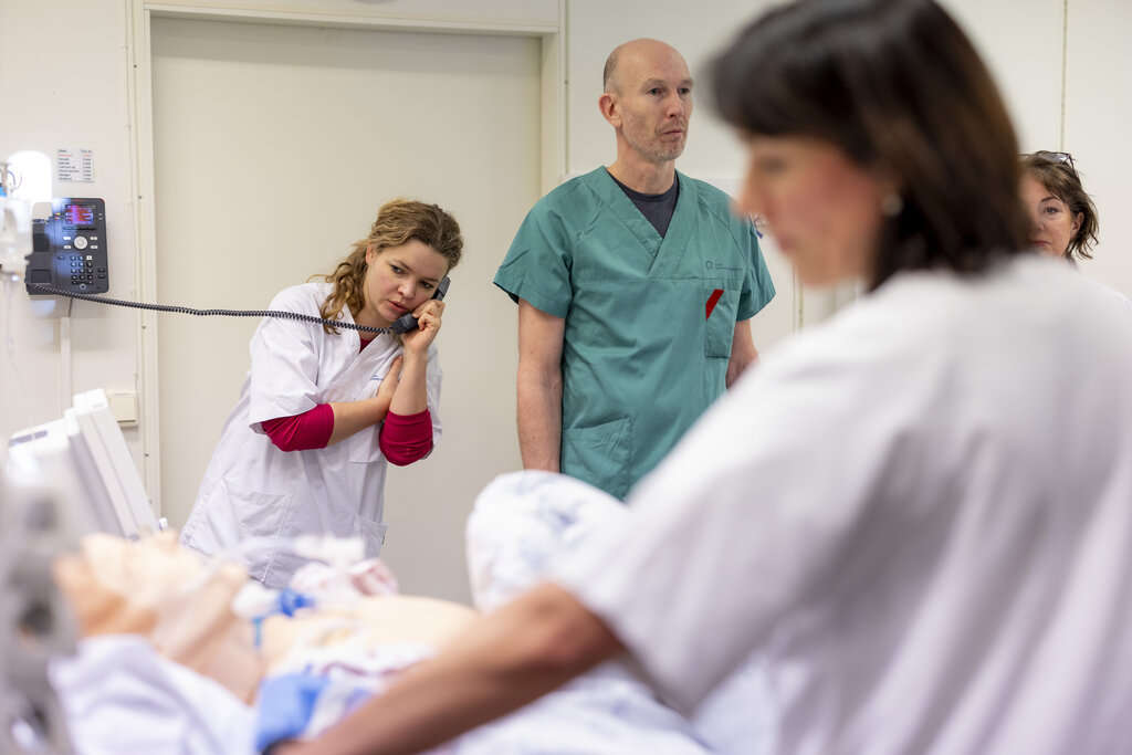 Bildet viser sykepleierstudenter og annet helsepersonell som simulerer pasientsituasjoner med bruk av en dokke.