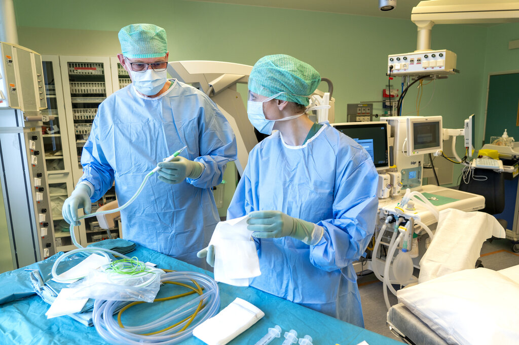 Bildet viser en kirurg og en sykepleier som forbereder medisinsk utstyr før en operasjon.