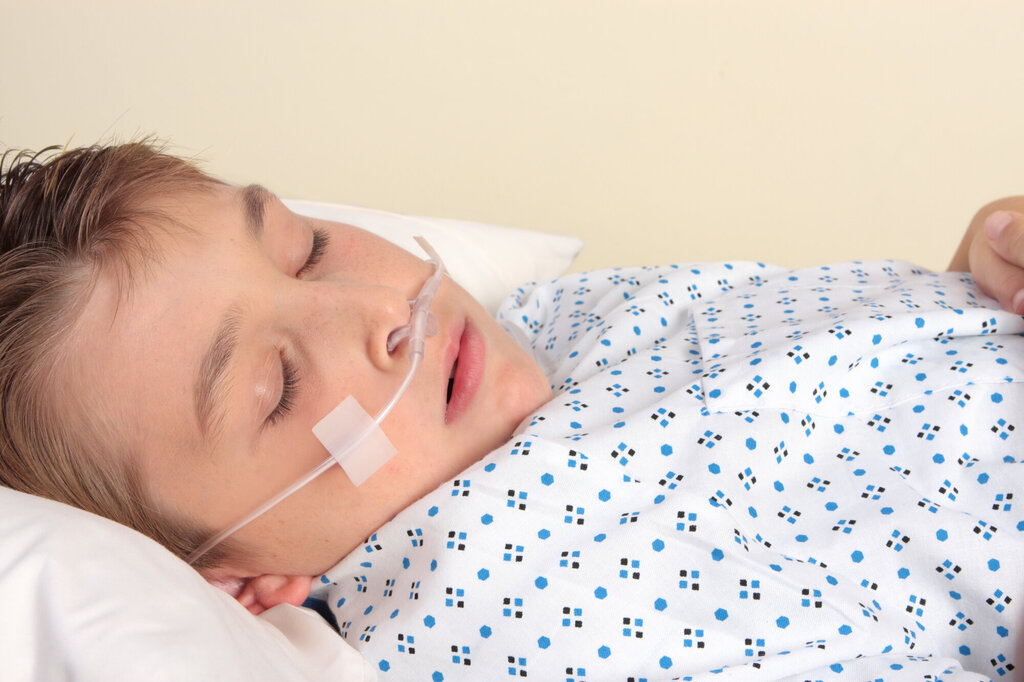 Bilde av gutt i sykehusseng med oksygenslange